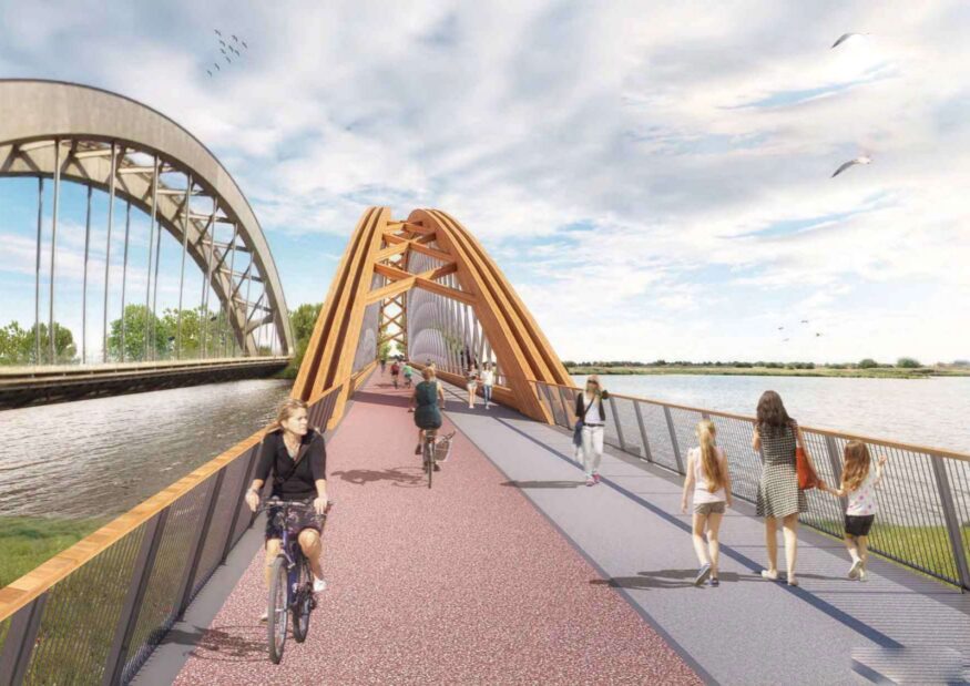 Impressie van hoe de fietsbrug naast de spoorbrug eruit zou kunnen zien. Een gele brug met bogen en een rood fietspad met naastgelegen voetpad. Er rijden fietsers en er lopen voetgangers.